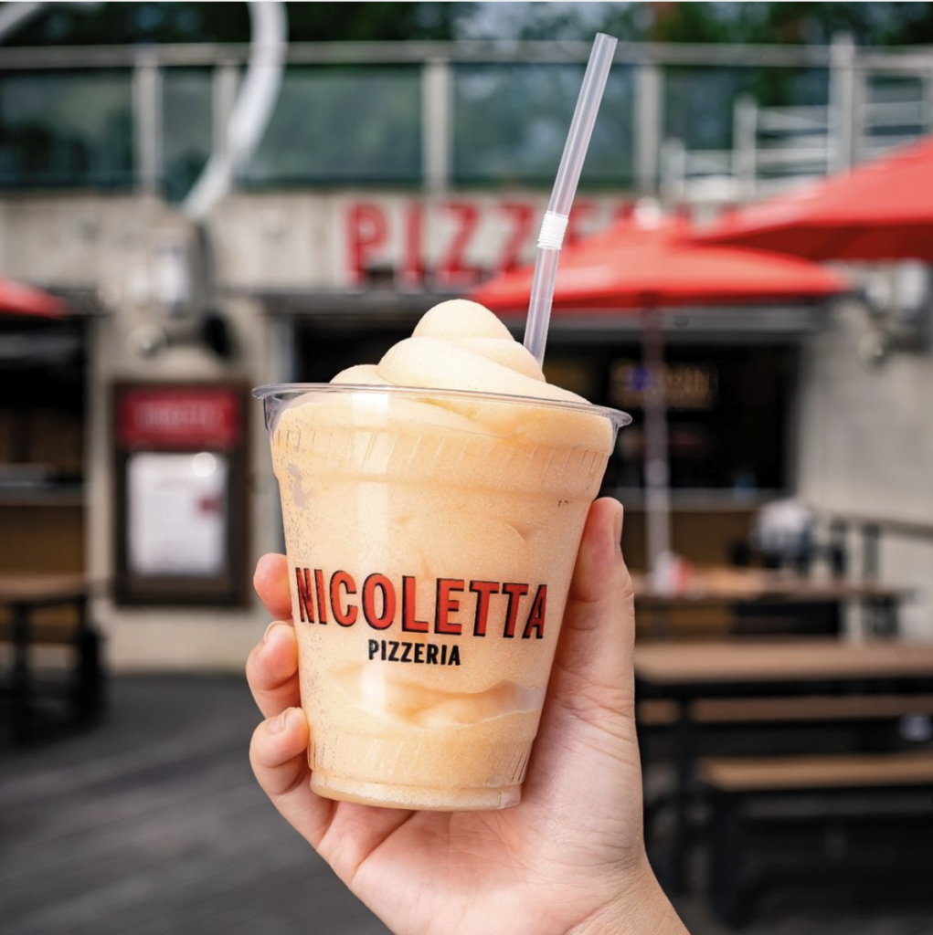 a hand holding a frozen lemonade at nicoletta pizzeria in dc